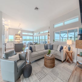 Unwind in your spacious living room with panoramic water views through floor-to-ceiling windows, perfect for morning coffee or evening relaxation.
