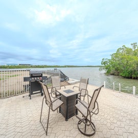 Your private waterfront patio with comfortable seating and BBQ grill offers stunning lake views for memorable outdoor dining experiences.